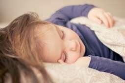 Toddler child asleep on back