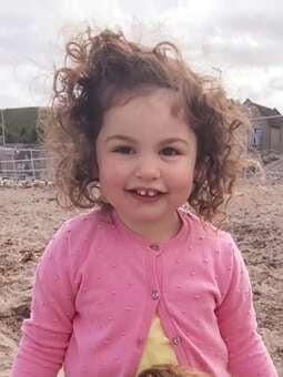 Toddler girl smiling with two front teeth